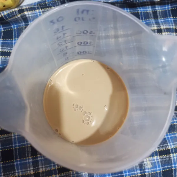 Seduh kopi hazelnut dengan air panas, lalu beri krimer dingin.