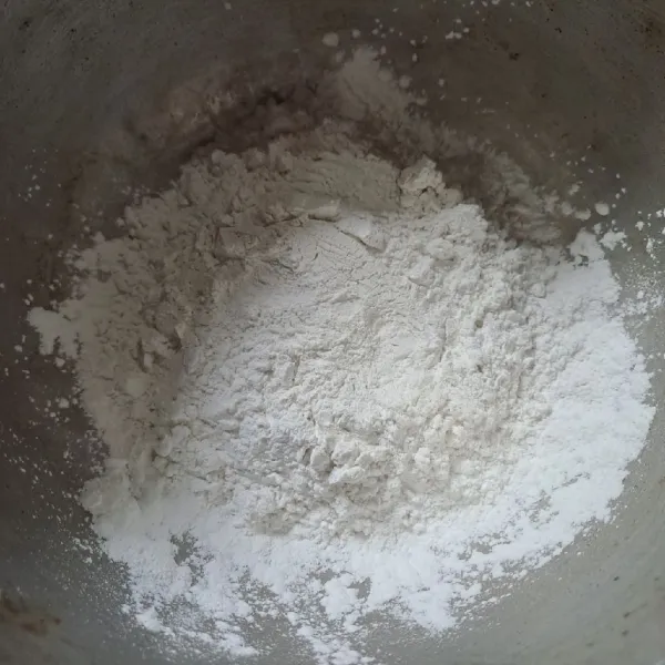 Tuang tepung beras dan garam dalam panci.