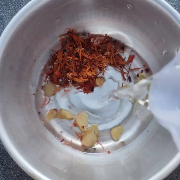 Masukkan kayu secang, jahe iris, gula batu dan air ke dalam panci.