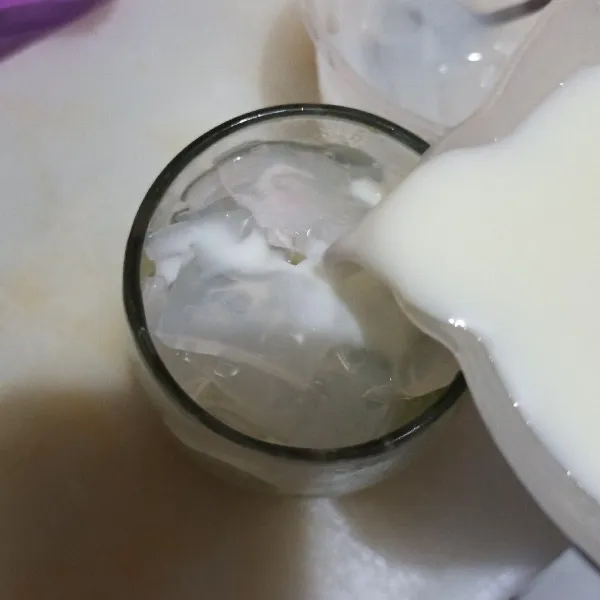 Tuang susu cair ke gelas.