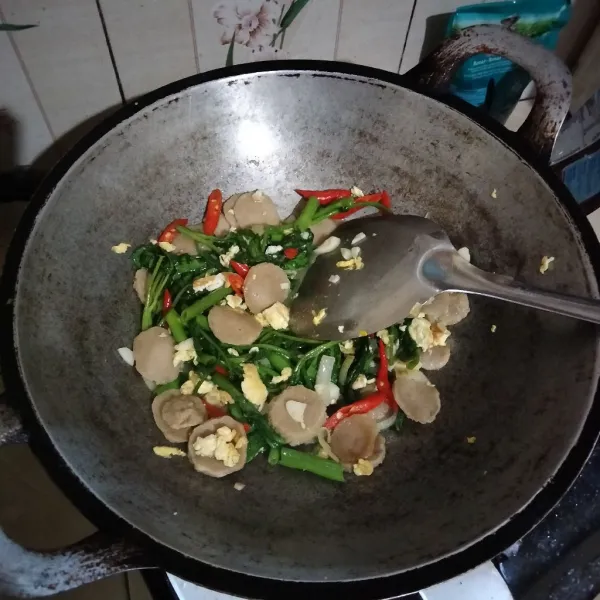 Masukkan kangkung lalu bumbui dengan garam, kaldu bubuk, dan merica bubuk. Masak hingga kangkung layu.