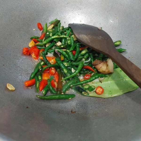 Masukkan cabai, laos, dan daun salam. Tumis hingga layu.