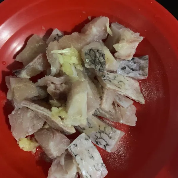 Siapkan ikan filet dan beri garam, kaldu jamur dan bawang putih, tambahkan tepung terigu dan sedikit air, aduk merata.