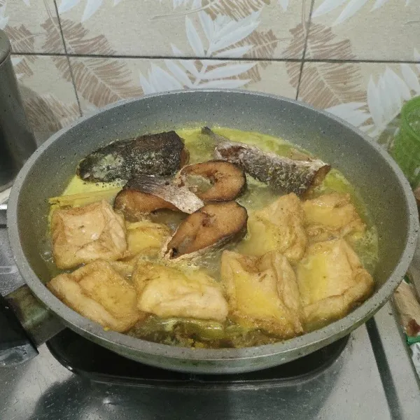 Masukkan ikan dan tahu goreng. Masak sampai bumbu meresap.