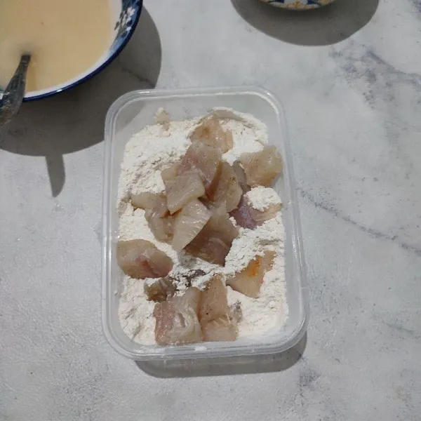 Gulingkan ikan dori ke atas tepung krispy. Aduk rata, atau bisa juga ditutup wadahnya lalu dikocok-kocok.