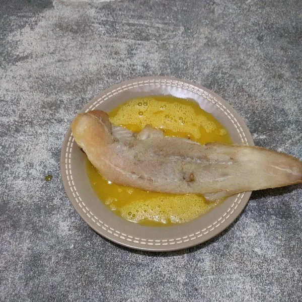 Celupkan ikan dori ke dalam kocokan telur.
