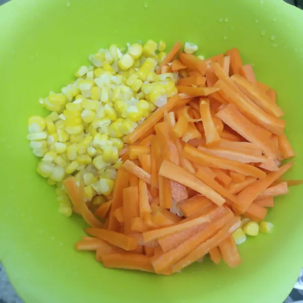 Potong dan bersihkan jagung serta wortel.