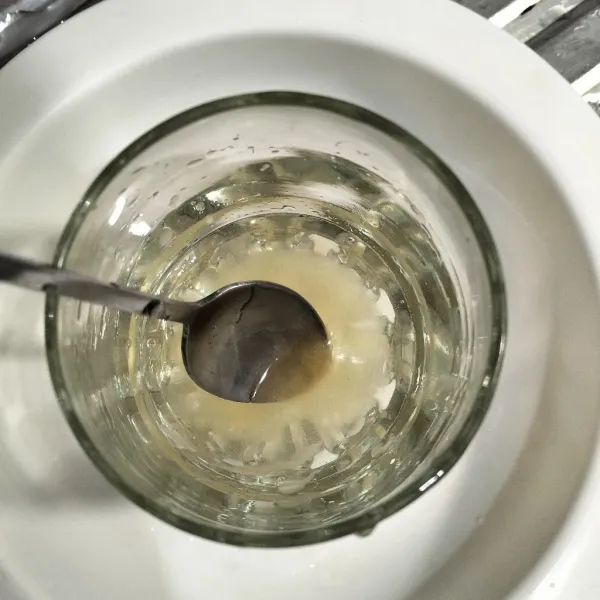 Dalam gelas larutkan madu dengan secukupnya air.