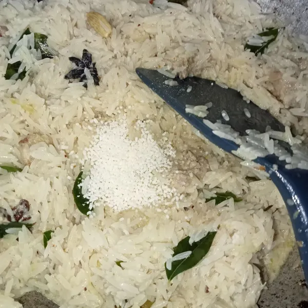 Masukkan nasi, garam, dan kaldu jamur. Aduk perlahan kemudian tutup rapat wajan. Diamkan 30 menit (supaya merekah menjadi nasi).
