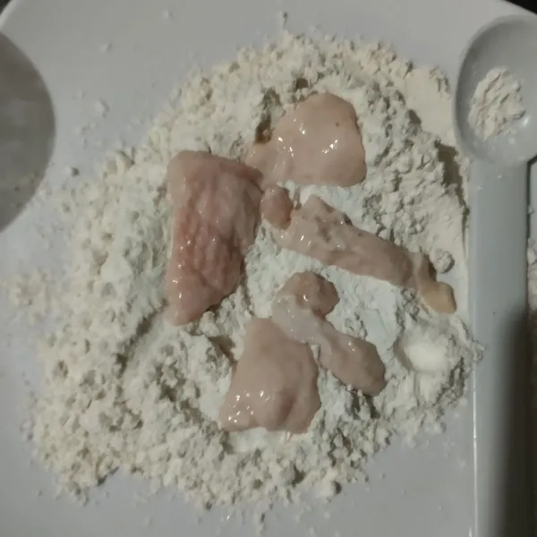 Gulingkan kulit ayam di atas tepung pelapis, balur rata.