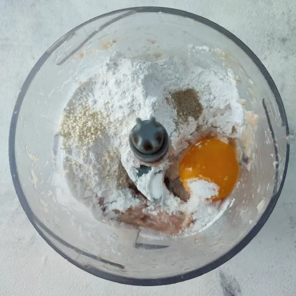 Tambahkan tepung tapioka, telur ayam, garam, merica bubuk dan kaldu jamur. Proses hingga tercampur rata.