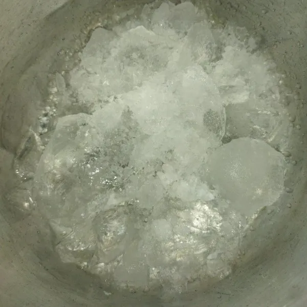 Siapkan es batu di dalam wadah yang agak besar.