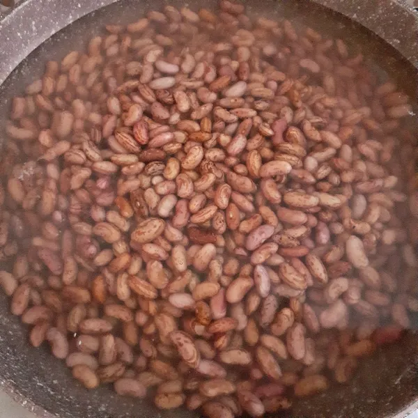 Masukkan kacang merah dan masak hingga mendidih, tambahkan soda kue dan masak hingga empuk. Setelah kacang merah empuk, bilas dan tiriskan.