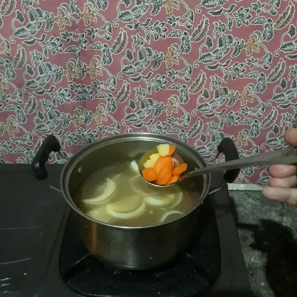 Tambahkan air lalu masukkan wortel dan kentang. Masak hingga empuk.