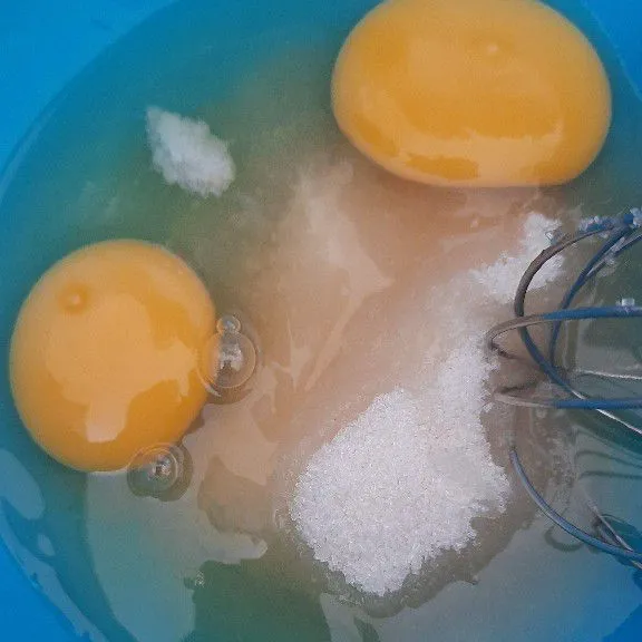 Aduk telur dan gula pasir sampai berbusa dan gula larut .