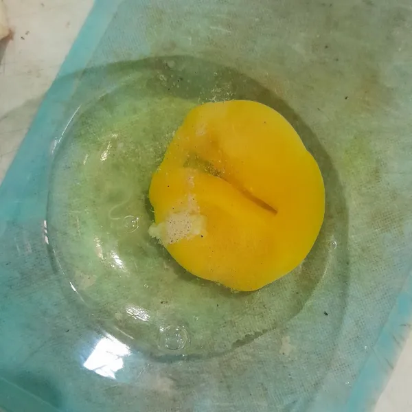 Pecahkan satu butir telur, beri sedikit garam.