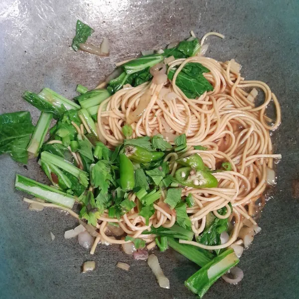 Tambahkan cabe rawit dan sedikit air, aduk sampai mie tercampur rata.