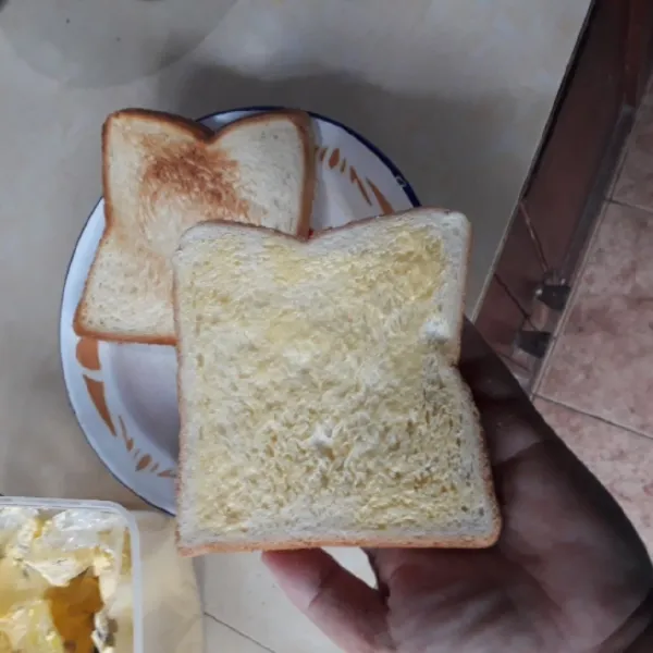 Olesi sisi roti yang tidak dipanggang dengan margarin.