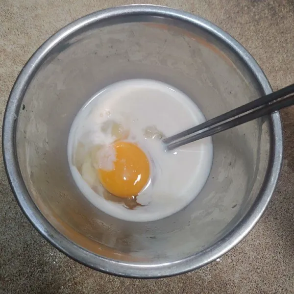 Dalam wadah terpisah pecahkan telur, beri susu dan garam lalu kocok rata.