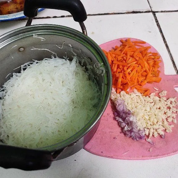 Rebus bihun 2-3 menit, tiriskan. Iris/parut kasar wortel, dan rajang kecil bawang merah putih.