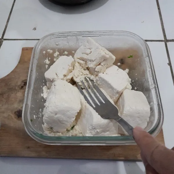 Hancurkan tahu dengan garpu.