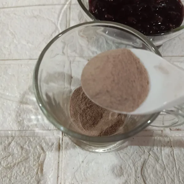 Tuang bubuk susu cokelat ke dalam gelas.