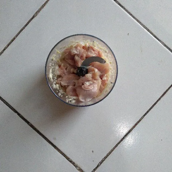 Haluskan daging ayam, telur dan bawang putih.