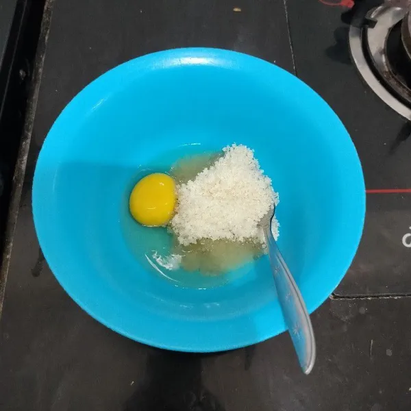 Masukkan telur dan gula pasir ke dalam mangkuk, kocok dengan garpu hingga gula larut.