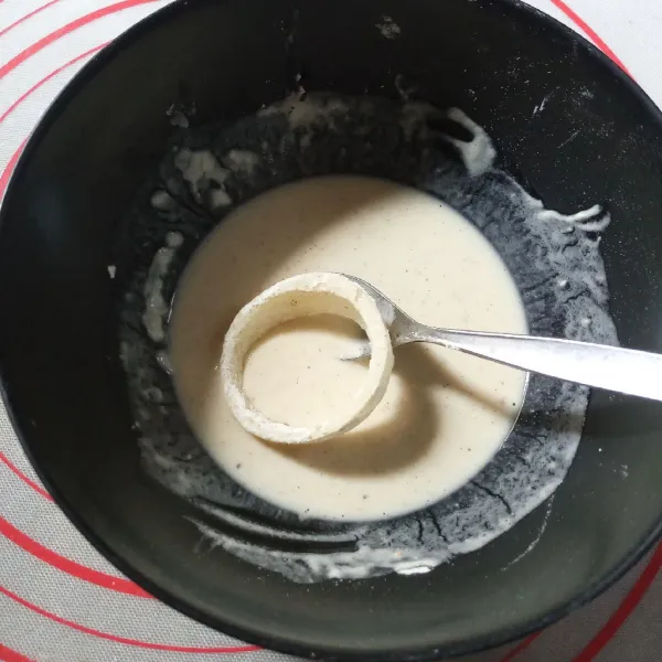 Tambahkan air es secukupnya pada sisa tepung kemudian aduk. Konsistensinya tidak encer tapi tidak terlalu kental juga. Celupkan bawang bombay ke dalam adonan basah kemudian gulingkan ke dalam tepung panir.