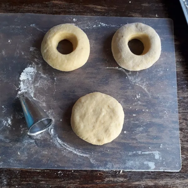 Kempiskan adonan, timbang seberat 50 gram, bulatkan dan pipihkan, lubangi bagian tengah. Diamkan selama 15 menit hingga mengembang.