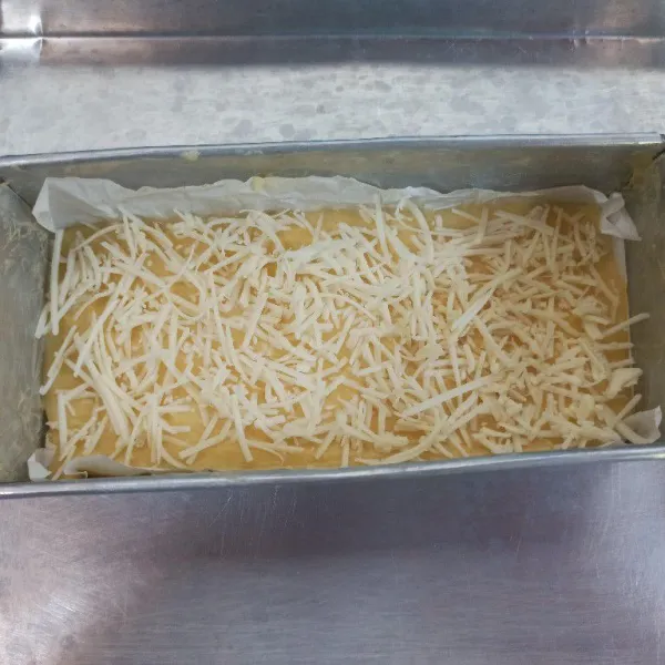 Siapkan loyang, olesi dengan margarin kemudian alasi dengan kertas kue, tuang adonan kemudian taburi dengan keju parut. Masukkan ke dalam oven yang sudah dipanaskan dan panggang hingga matang.