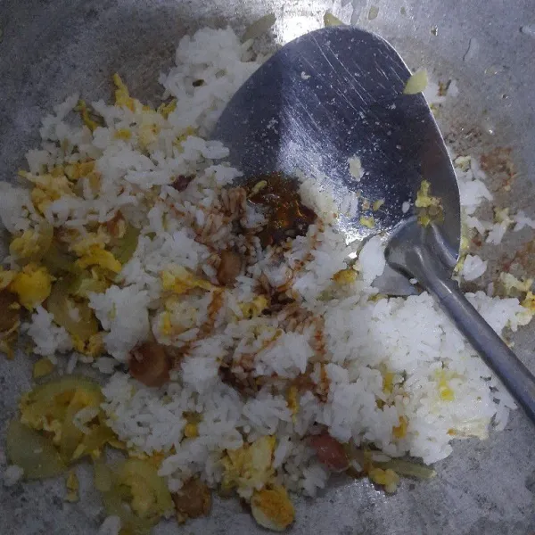 Tambahkan nasi, lalu beri bumbu penyedap rasa ayam dan kecap manis 1/2 sdm, kemudian masak sampai tercampur rata dengan nasi. Tes rasa, hidangkan nasi goreng jadul dengan kerupuk.