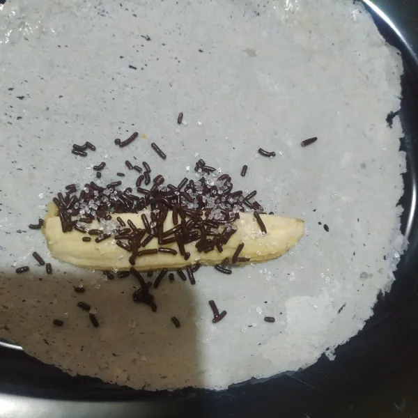 Siapkan selembar kulit lumpia, beri potongan pisang, meses cokelat dan gula pasir.