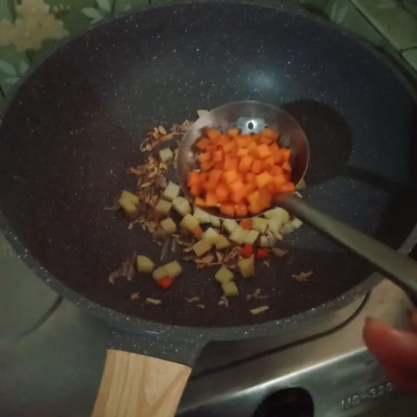 Masukkan kentang, wortel lalu tumis kembali hingga wortel layu.