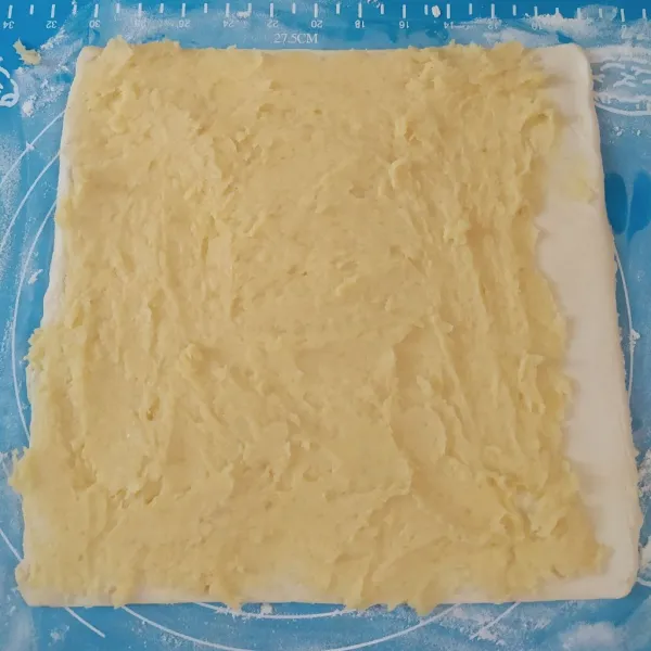 Baluri pastry dengan sedikit tepung. Olesi dengan adonan tape, sisakan sedikit bagian ujungnya. Olesi dengan sedikit putih telur.