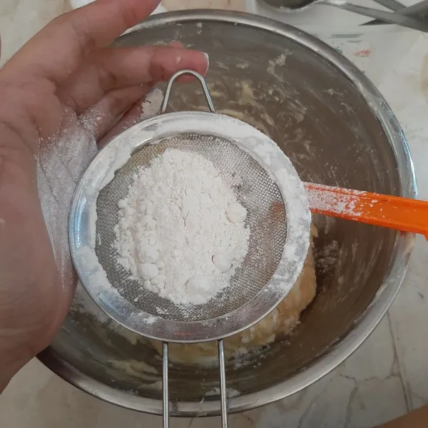 Tambahkan tepung sambil diayak. Kemudian aduk rata hingga adonan bisa dibentuk.