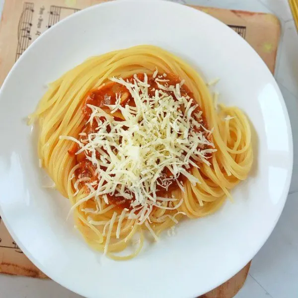 Tambahkan saus bolognese dan parutan keju di atasnya. Sajikan.