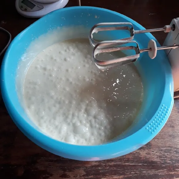 Campurkan skm dan air, aduk rata. Masukkan air secara bertahap ke adonan telur sambil di mixer hingga kental selama 8 menit.