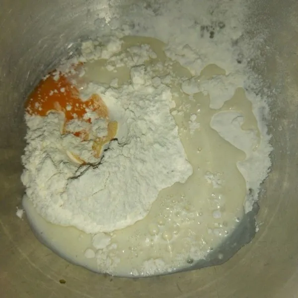 Siapkan wadah, masukkan tepung terigu, garam, kuning telur dan susu cair, uleni hingga tercampur rata.