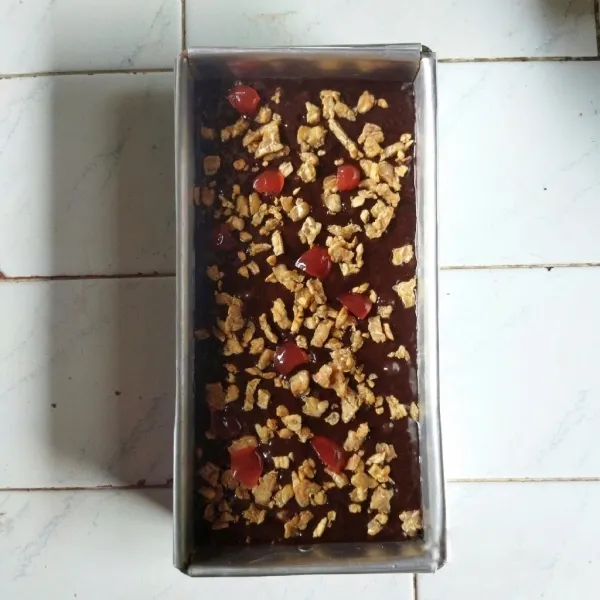 Siapkan loyang berukuran 10x20 cm yang telah dialasi dengan kertas roti, tuangkan adonan ke dalam loyang dan ratakan dengan spatula. Topping dengan tempe goreng dan cherry merah.