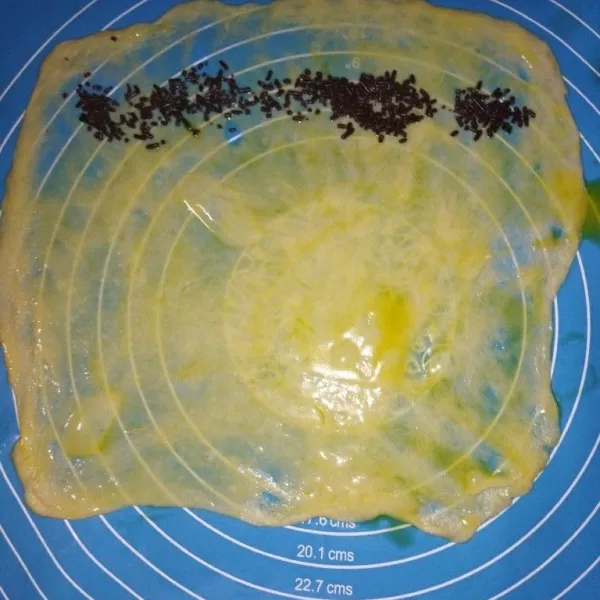 Ambil 1 bulatan, buat adonan setipis mungkin, oles permukaannya dengan margarin yang sudah dilelehkan, lalu tata meses di salah satu sisi.