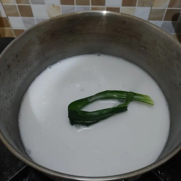 Membuat vla santan : masukkan santan, garam, air dan daun pandan, masak dengan api kecil sambil diaduk.