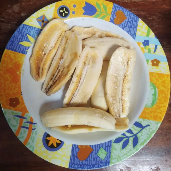 Belah pisang menjadi 2 bagian.