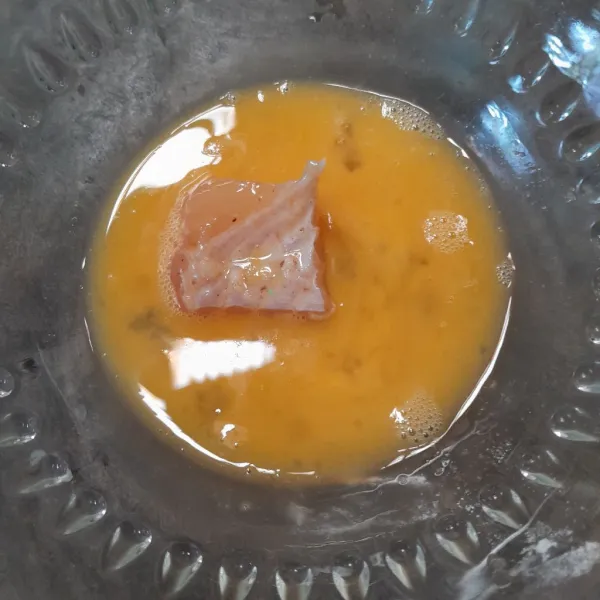 Kocok telur dan garam, cemplungkan ikan ke dalam telur.