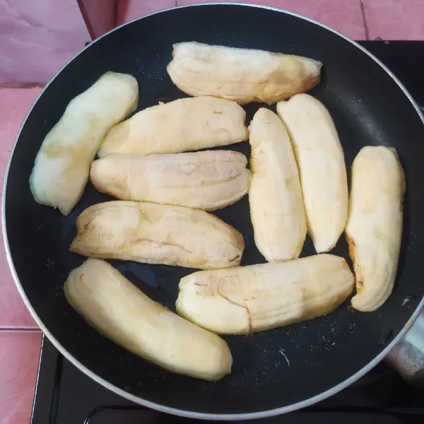 Panaskan pan anti lengket dengan api kecil, olesi dengan margarin lalu tata pisang di atasnya.