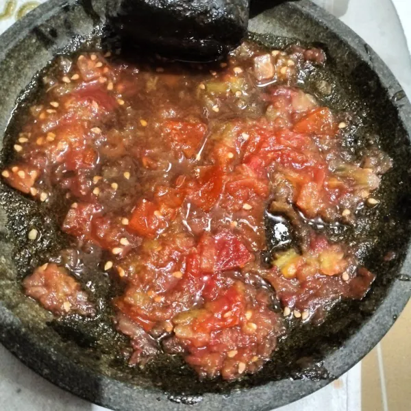 Ulek tomat, bawang putih dan cabe sampai halus. Beri garam dan kaldu jamur.