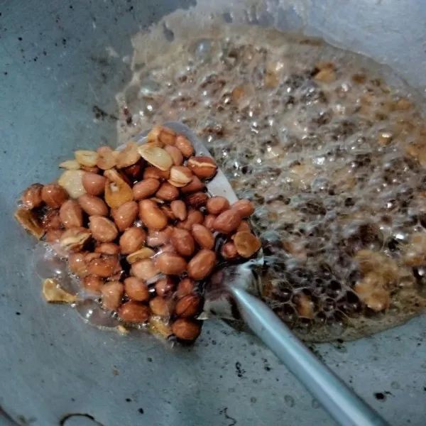 Goreng kacang dan bawang putih iris hingga matang. Angkat dan tiriskan, kemudian haluskan bersama dengan cabe rawit.