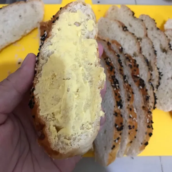 Untuk membuat bagelen, iris roti sesuai selera, olesi dengan margarin pada kedua sisinya.