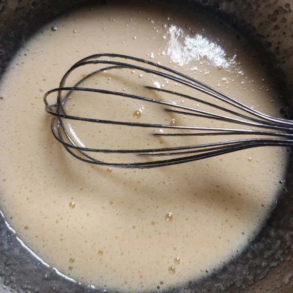 Campur gula pasir dan telur, kocok dengan whisk hingga gula larut.