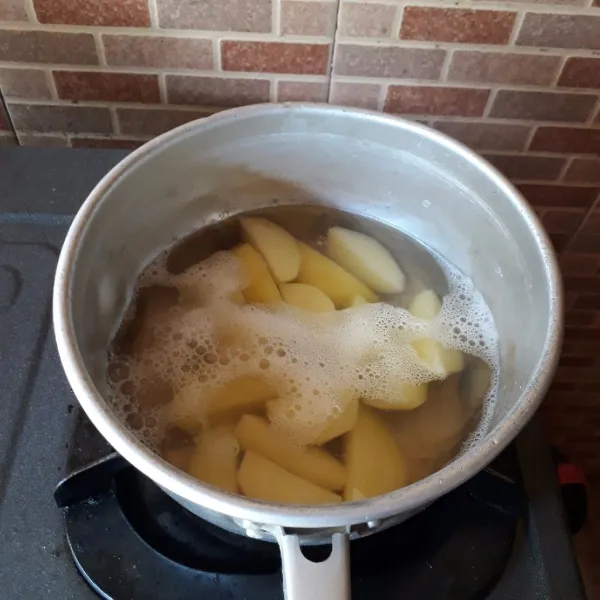 Kupas kentang, potong dan rebus hingga empuk.